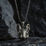 Oxidized 925 sterling silver mouse head pendant with detailed fur texture and large eyes, hanging on a chain against a dark rock.
