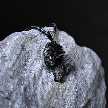 Detailed Native American pendant with a snake chain, showcasing the intricate feathers of the headdress against a dark background.