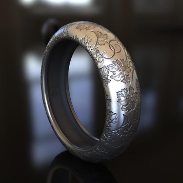 Close-up of nature inspired ring design with delicate branch motifs and organic textures on silver band