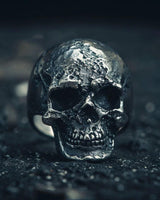 925 sterling silver skull ring with weathered bone texture and oxidized finish on dark background showing fine detail
