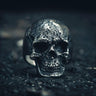925 sterling silver skull ring with weathered bone texture and oxidized finish on dark background showing fine detail