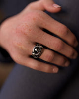 Gothic-style silver snake skull ring worn on a man's finger, showcasing its size and bold biker aesthetic.