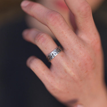 A unisex hammered silver Moon ring with a celestial lunar texture worn on a person's finger, showing its fit and style.