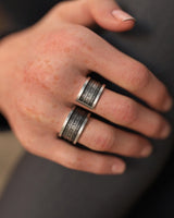 Unisex silver spell ring worn across two fingers, showcasing the bold, four-band fantasy design and adjustable fit on a hand.