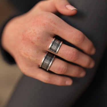 Unisex silver spell ring worn across two fingers, showcasing the bold, four-band fantasy design and adjustable fit on a hand.