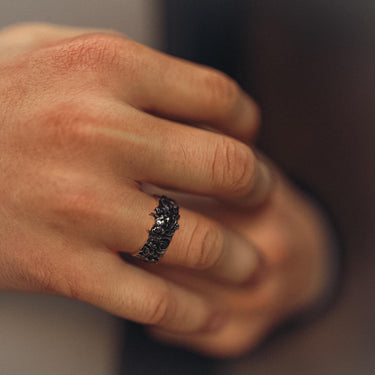 A man wearing the gothic-style Hannya mask ring, showcasing its fit and the bold, antique finish on his finger.