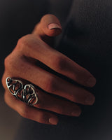 A woman wearing the elegant silver butterfly wing ring on her index finger, showcasing its scale and graceful fit against a dark background.