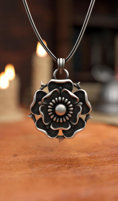 Render of the silver Tudor Rose Pendant on a snake chain with a warm, atmospheric background of lit candles.