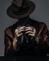 Handmade Oni mask ring for men styled with a leather jacket and other silver jewelry, creating a mysterious, high-fashion look.
