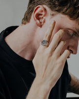 Man wearing handcrafted German eagle signet ring showing oxidized sterling silver finish and detailed craftsmanship