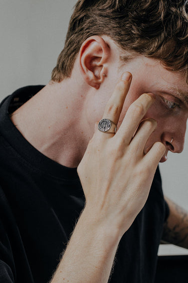 Man wearing handcrafted German eagle signet ring showing oxidized sterling silver finish and detailed craftsmanship