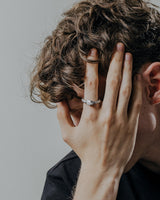 Handcrafted ouroboros ring worn on finger displaying intricate scale texture and oxidized silver finish detail