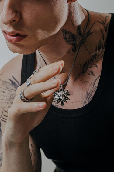 Side view of sterling silver wolf medallion pendant displaying three-dimensional spikes and wolf head detail