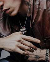 Close-up of witcher wolf pendant showing intricate metalwork and oxidized finish on tattooed model