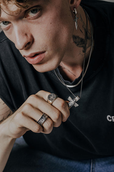 Model wearing the Last Supper Ring with other silver jewelry, highlighting its style as a bold Christian statement piece.