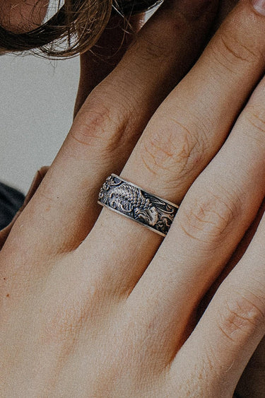 Silver Koi Fish Ring with detailed Japanese waves worn on a finger, showcasing the handcrafted oxidized finish and texture.