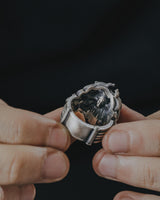 A person holding the sterling silver Medusa ring, revealing the secret hidden skull design carved on the inside of the band.