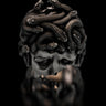 Silver Medusa ring with detailed, oxidized snakes for hair, shown on a reflective black background for a luxury feel.