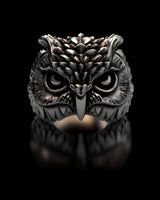 High-detail studio render of the silver owl ring on a black reflective surface, showcasing its piercing eyes and oxidized finish.