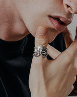 Man wearing the Silver Octopus Ring, showing its detailed tentacles and oxidized finish as it wraps around his finger.
