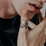 Man wearing the Silver Octopus Ring, showing its detailed tentacles and oxidized finish as it wraps around his finger.