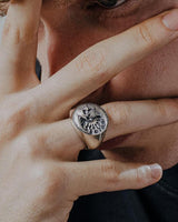 Man wearing a sterling silver statement ring, embodying a bold and edgy aesthetic ideal for our gothic biker collection.