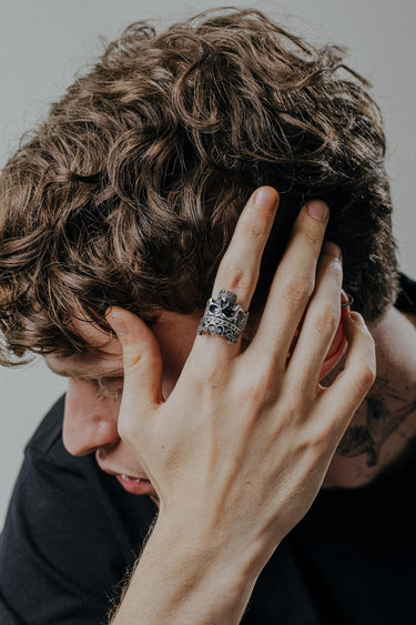 Lifestyle photo of the silver Skull King Ring worn by a man with curly hair, highlighting its bold statement style and design.