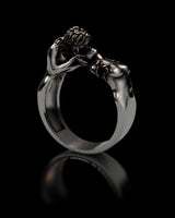 Side angle view of handcrafted LGBTQ pride ring displaying sculptural couple embrace and oxidized silver finish