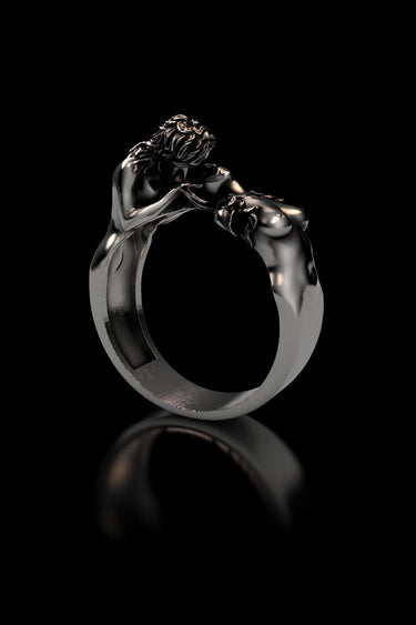 Side angle view of handcrafted LGBTQ pride ring displaying sculptural couple embrace and oxidized silver finish