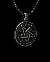 Detailed close-up view of handcrafted pentagram pendant showing oxidized finish and intricate sorceress symbols