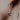 Sterling silver hanging bat earring worn in an ear, showing the detailed sleeping bat charm and branded huggie hoop.