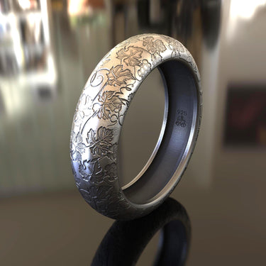 Side view of handcrafted botanical ring showing detailed leaf patterns and oxidized finish on sterling silver