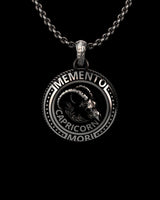 Silver Capricorn skull pendant with 'Memento Mori' text, featuring a detailed goat skull design on a sterling silver chain.