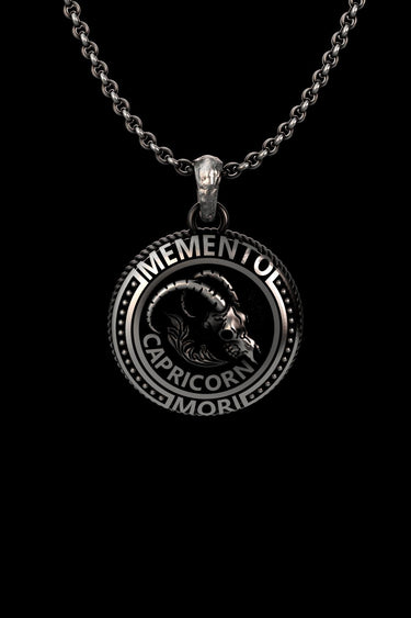 Silver Capricorn skull pendant with 'Memento Mori' text, featuring a detailed goat skull design on a sterling silver chain.