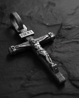 Close-up of sterling silver crucifix pendant displaying intricate religious craftsmanship and sacred symbolism