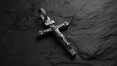 Close-up of sterling silver crucifix pendant displaying intricate religious craftsmanship and sacred symbolism