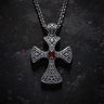 Gold vermeil Celtic cross pendant with red garnet stone and intricate knotwork on dark textured background