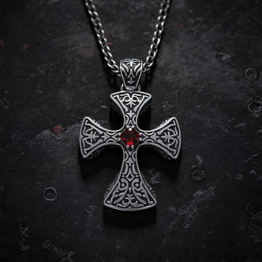 Gold vermeil Celtic cross pendant with red garnet stone and intricate knotwork on dark textured background