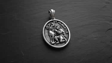 Gold vermeil Saint Hubert pendant showing detailed relief of saint with stag on dark slate background