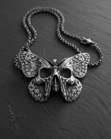 925 sterling silver butterfly skull pendant with detailed wings and gothic design on dark wooden surface