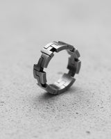 925 sterling silver geometric ring with angular segments displayed on textured concrete surface showing modern design