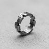 925 sterling silver geometric ring with angular segments displayed on textured concrete surface showing modern design