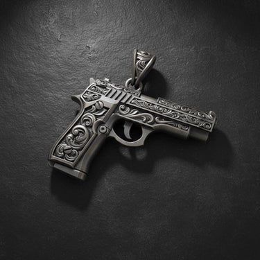 Close-up of ornate pistol pendant with intricate metalwork and decorative patterns on sterling silver