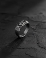 Side angle of silver dwarven ring highlighting geometric design elements and band thickness profile