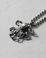 925 sterling silver octopus pendant with detailed tentacles and sucker patterns displayed on textured surface