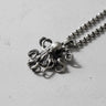 925 sterling silver octopus pendant with detailed tentacles and sucker patterns displayed on textured surface
