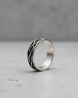 925 sterling silver infinity ring with interwoven pattern displayed on white marble surface showing elegant design