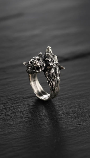 925 sterling silver double wolf head ring with detailed fur texture and oxidized finish on dark wooden background