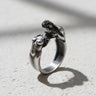 925 sterling silver lovers ring with two intimate figures embracing displayed on textured stone surface