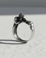 Side view of handcrafted romantic ring showing detailed sculptural figures and oxidized silver finish